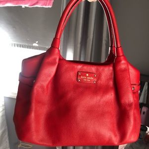 Red Kate Spade shoulder bag with zipper closure.